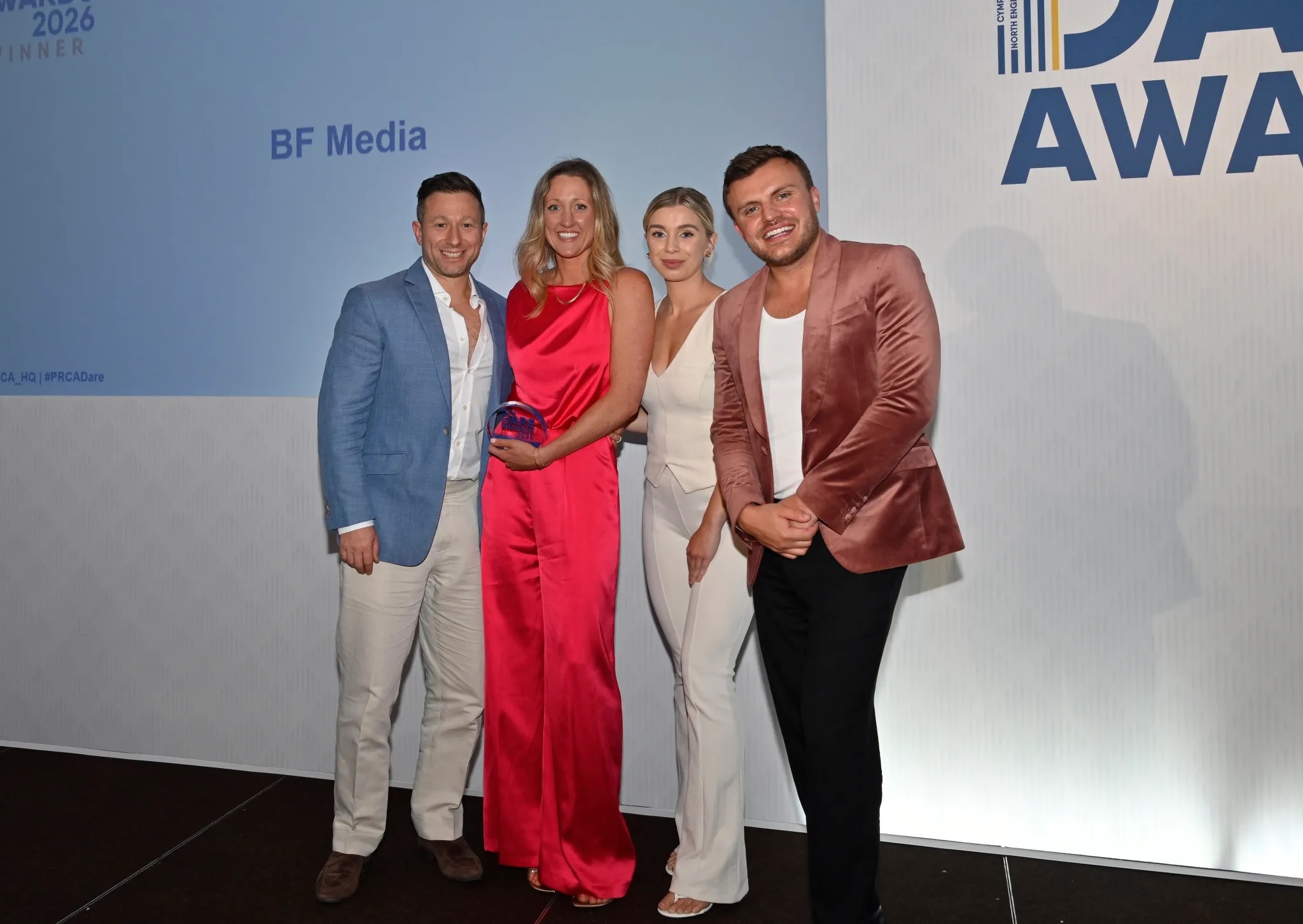 BF Media team of four people at a step and repeat at an awards