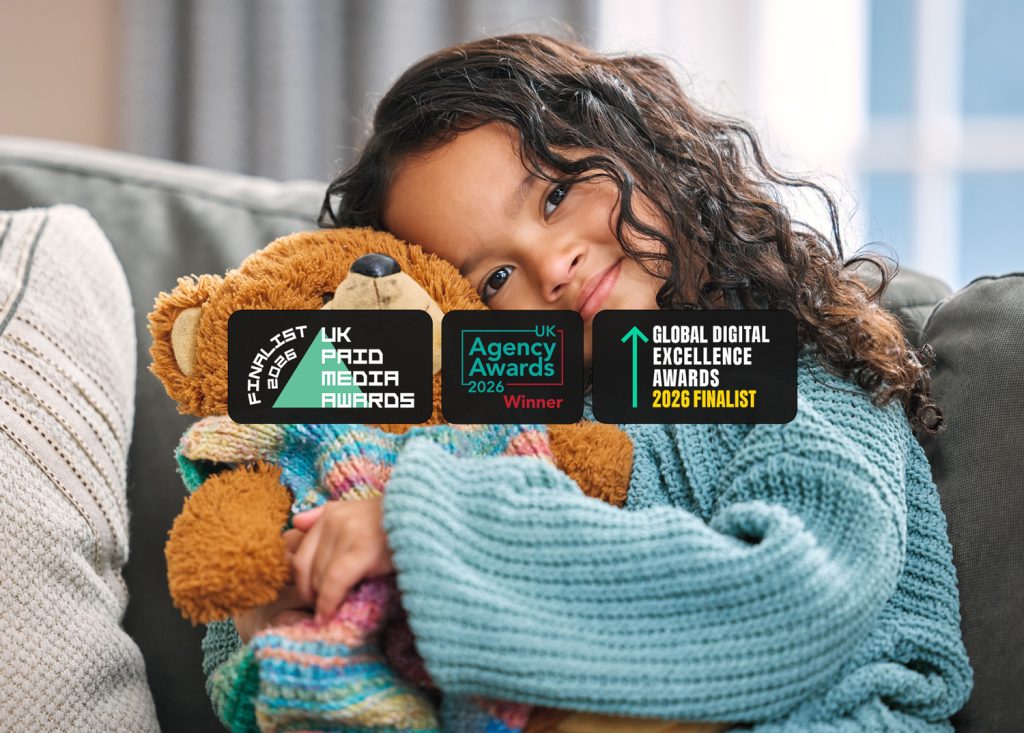 a child of about 10 smiling to camera with award logos